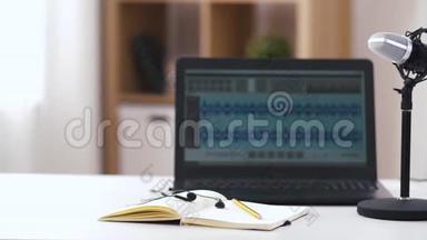 桌上笔记本上的麦克风、笔记本电脑和耳机